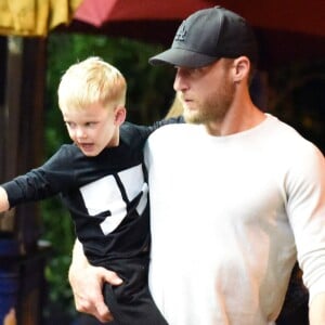 Exclusif - Hilary Duff embrasse son compagnon Jason Walsh (qui porte son fils Luca sur ses épaules!) à la sortie d'un marché à Los Angeles, le 31 octobre 2016. 