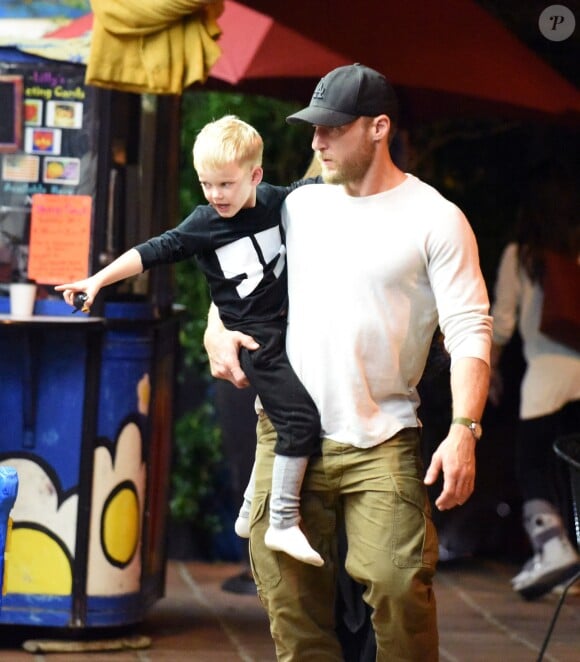 Exclusif - Hilary Duff embrasse son compagnon Jason Walsh (qui porte son fils Luca sur ses épaules!) à la sortie d'un marché à Los Angeles, le 31 octobre 2016. 