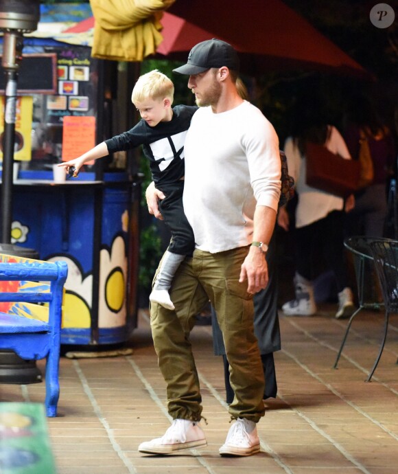 Exclusif - Hilary Duff embrasse son compagnon Jason Walsh (qui porte son fils Luca sur ses épaules!) à la sortie d'un marché à Los Angeles, le 31 octobre 2016. 