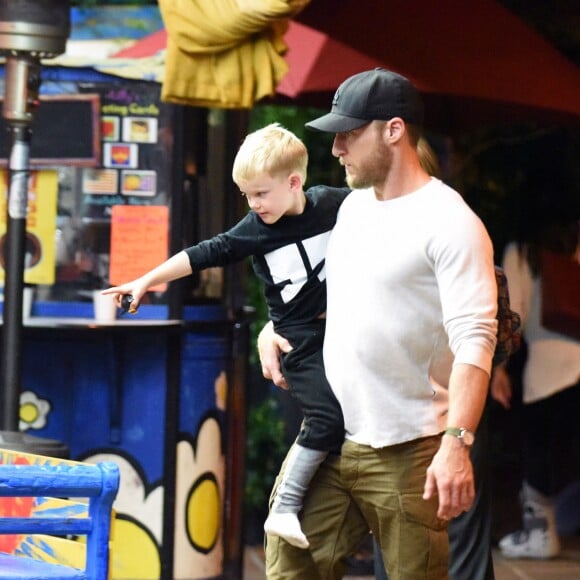 Exclusif - Hilary Duff embrasse son compagnon Jason Walsh (qui porte son fils Luca sur ses épaules!) à la sortie d'un marché à Los Angeles, le 31 octobre 2016. 