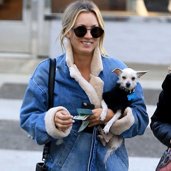 Exclusif - Kaley Cuoco est allée déjeuner avec une amie au restaurant Porto Villa à Beverly Hills. Elle porte son petit chien blanc dans les bras. Le 16 novembre 2016