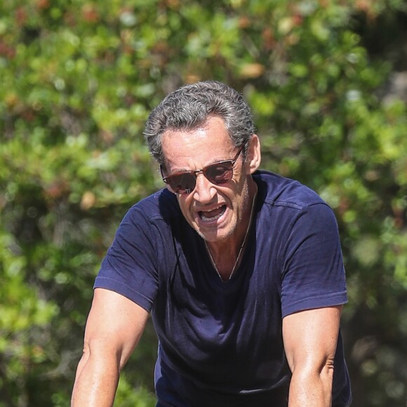 Nicolas Sarkozy fait du velo au Lavandou pendant ses vacances accompagné d'un garde du corps le 31 juillet 2016.
