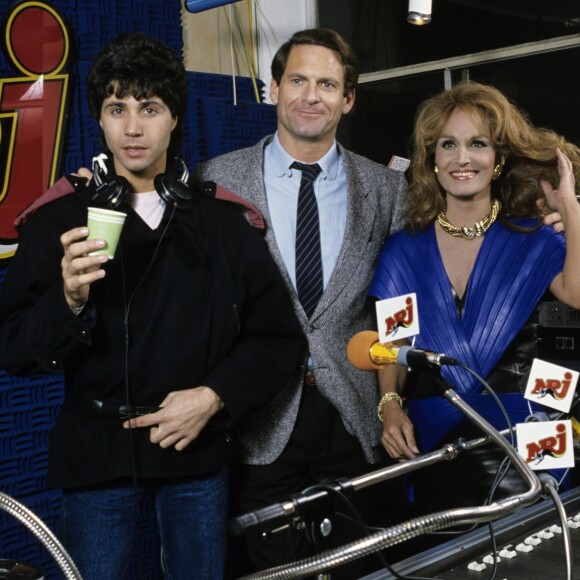 Archives - En France, à Paris, dans les studios de la radio NRJ, Jean-Luc Lahaye, Paul Baudecroux et Dalida le 21 décembre 1984.