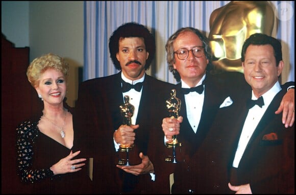 John Barry, oscarisé pour la musique d'Out of Africa, entouré de Debbie Reynolds et Lionel Richie lors des Oscars 1986.