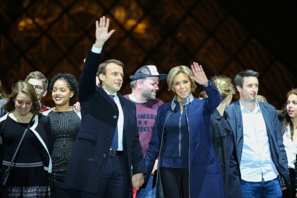 Emmanuel Macron, élu président de la république, et sa femme Brigitte Macron (Trogneux), saluent les militants devant la pyramide au musée du Louvre à Paris, après sa victoire lors du deuxième tour de l'élection présidentielle. Le 7 mai 2017.