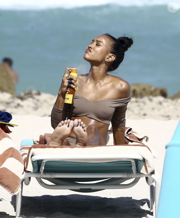 Karrueche Tran profite d'une belle journée ensoleillée avec des amis sur une plage à Miami. Elle a des ongles XXL jaune le 15 avril 2017