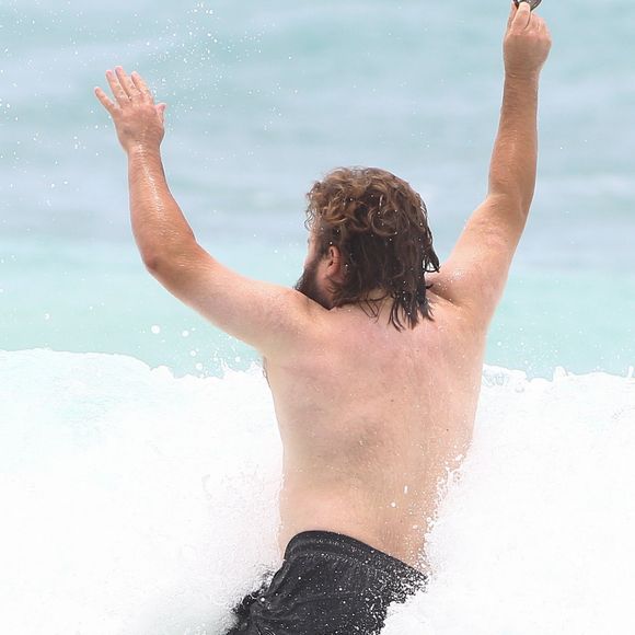 Exclusif - Haley Joel Osment (acteur du film 'Sixth Sense’) s’amuse dans les vagues avec une mystérieuse inconnue lors de ses vacances à Cancun au Mexique, le 26 mai 2017