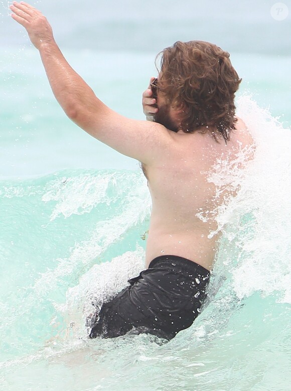Exclusif - Haley Joel Osment (acteur du film 'Sixth Sense’) s’amuse dans les vagues avec une mystérieuse inconnue lors de ses vacances à Cancun au Mexique, le 26 mai 2017