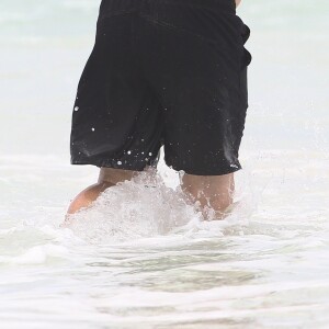 Exclusif - Haley Joel Osment (acteur du film 'Sixth Sense’) s’amuse dans les vagues avec une mystérieuse inconnue lors de ses vacances à Cancun au Mexique, le 26 mai 2017