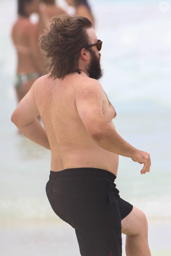 Exclusif - Haley Joel Osment (acteur du film 'Sixth Sense’) s’amuse dans les vagues avec une mystérieuse inconnue lors de ses vacances à Cancun au Mexique, le 26 mai 2017