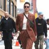 Kendall Jenner photographiée à New York le 5 juin 2017, porte une veste et un pantalon rayés Wolk Morais ("Collection 5", automne-hiver 2017), une banane Louis Vuitton et des baskets YEEZY (modèle adidas Powerphase "Calabasas").