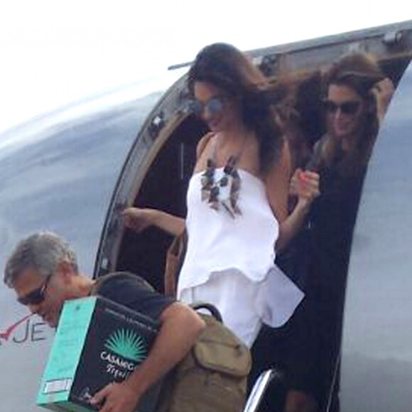 Exclusif - George Clooney et sa femme Amal Alamuddin Clooney débarquent d'un jet à Ibiza en compagnie de Cindy Crawford et son mari Rande Gerber le 22 août 2015. Il descend de l'avion avec un carton de sa Tequila "Casamigos" sous le bras