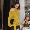 Kendall Jenner quitte le restaurant L'Avenue, habillée d'un pull Dion Lee (collection croisière 2018), d'un short Vatanika et de sandales Jimmy Choo. Des lunettes de soleil Andy Wolf (modèle Ojala) et une pochette noire accessoirisent sa tenue. Le 3 juillet 2017.