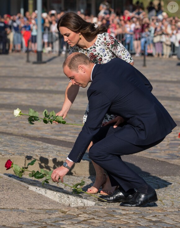 Kate Middleton et le prince William ont déposé des roses devant le monument aux morts des chantiers navals au Musée de la solidarité européenne à Gdansk le 18 juillet 2017, où ils ont eu l'ancien président Lech Walesa pour guide, au cours de leur visite officielle en Pologne.