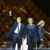 Emmanuel Macron, élu président de la république, et sa femme Brigitte Macron, saluent les militants devant la pyramide au musée du Louvre à Paris, après sa victoire lors du deuxième tour de l'élection présidentielle. Le 7 mai 2017.
