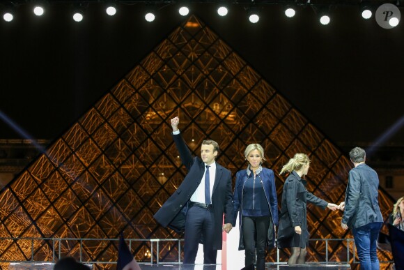 Emmanuel Macron, élu président de la république, et sa femme Brigitte Macron, saluent les militants devant la pyramide au musée du Louvre à Paris, après sa victoire lors du deuxième tour de l'élection présidentielle. Le 7 mai 2017.