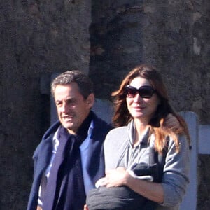NICOLAS SARKOZY, EN PAPA ATTENTIONNE, SE BALADE AVEC SA FEMME CARLA BRUNI-SAKOZY, QUI AFFICHE DEJA UNE BELLE LIGNE, ET LEUR PETITE GIULIA, A LA LANTERNE, DANS LE PARC DU CHATEAU DE VERSAILLES. LE PRESIDENT ENLACE TENDREMENT SON EPOUSE QUI TIENT LE BEBE. 2011.31/10/2011 - VERSAILLES