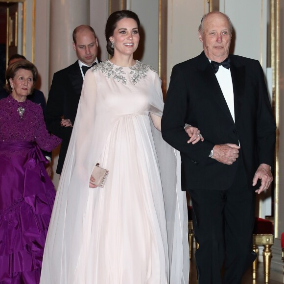 La duchesse Catherine de Cambridge, enceinte et en Alexander McQueen, arrive au bras du roi Harald V de Norvège au palais royal à Oslo le 1er février 2018 pour le dîner organisé dans le cadre de sa visite officielle avec le prince William, qui suit en donnant le bras à la reine Sonja.