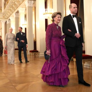 Le prince William donnant le bras à la reine Sonja de Norvège lors du dîner officiel donné par le roi Harald V de Norvège au palais royal à Oslo le 1er février 2018 dans le cadre de sa visite avec la duchesse Catherine.