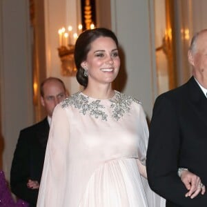 La duchesse Catherine de Cambridge, enceinte et en Alexander McQueen, arrive au bras du roi Harald V de Norvège au palais royal à Oslo le 1er février 2018 pour le dîner organisé dans le cadre de sa visite officielle avec le prince William.