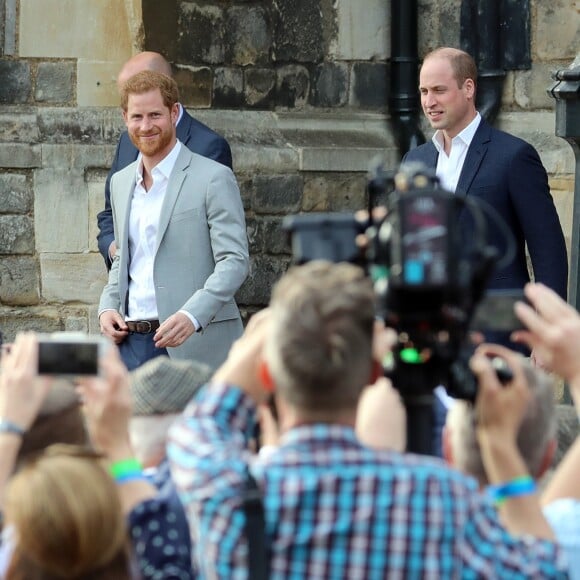 Le prince Harry et le prince William, son témoin, saluent la foule rassemblée aux abords du château de Windsor, le 18 mai 2018.