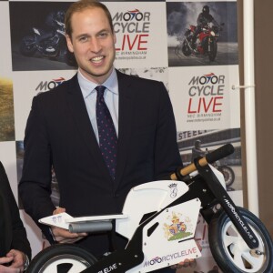 Le prince William recevant en novembre 2013 une petite moto en cadeau pour son fils le prince George de Cambridge, à Birmingham.