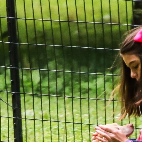 Suri Cruise, une attelle à la cheville, joue avec ses chiens dans un parc à New York, le 23 juin 2018