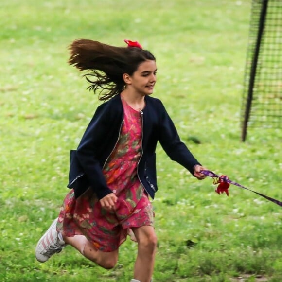 Suri Cruise, une attelle à la cheville, joue avec ses chiens dans un parc à New York, le 23 juin 2018