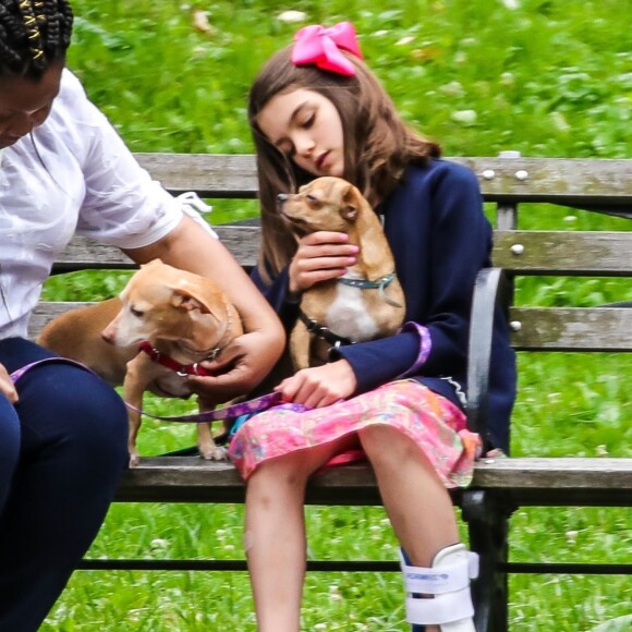 Suri Cruise, une attelle à la cheville, joue avec ses chiens dans un parc à New York, le 23 juin 2018.