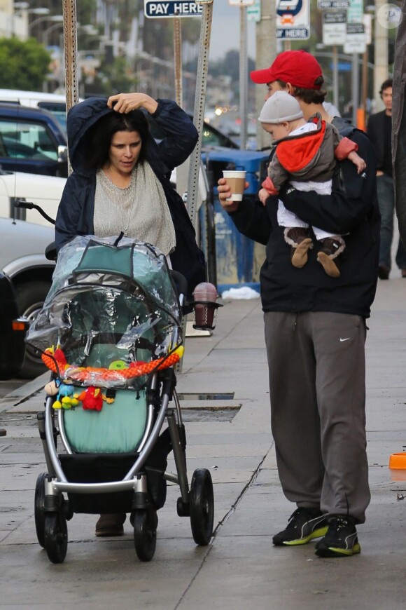 Neve Campbell et son compagnon l'acteur J.J. Feild de sortie sous la pluie avec le petit Caspian dans les rues de Los Angeles le 2 décembre 2012.