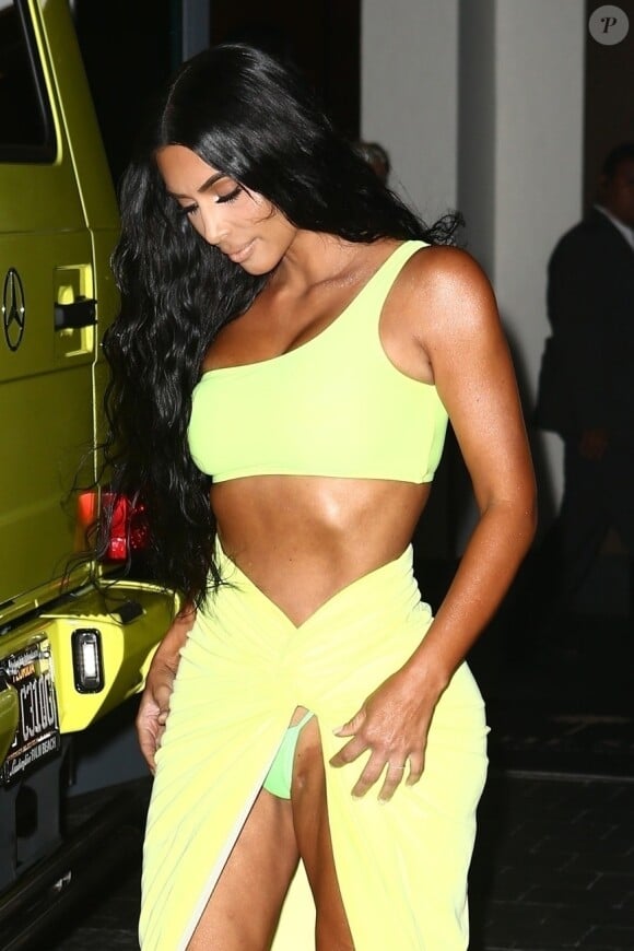 Kim Kardashian vêtue d'une tenue fluorescente et string apparent profite de la nuit avec ses amis Jonathan Cheban et Larsa Pippen à Miami le 17 août 2018.