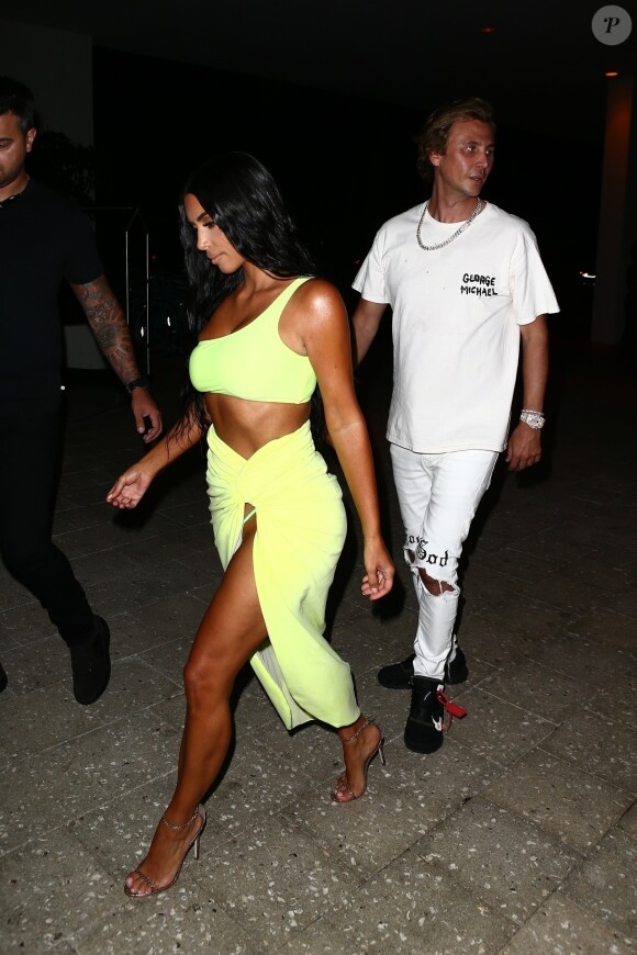 Kim Kardashian vêtue d'une tenue fluorescente profite de la nuit avec ses amis Jonathan Cheban et Larsa Pippen à Miami le 17 août 2018. N