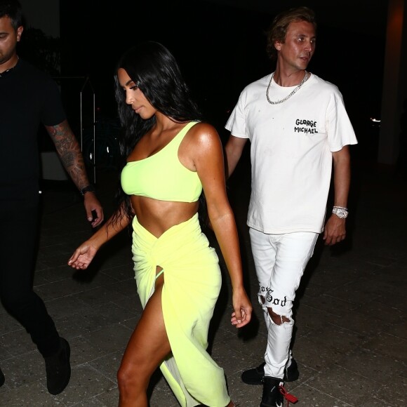 Kim Kardashian vêtue d'une tenue fluorescente profite de la nuit avec ses amis Jonathan Cheban et Larsa Pippen à Miami le 17 août 2018. N
