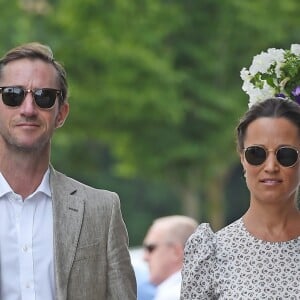 Pippa Middleton et son mari James Matthews se tiennent la main alors qu'ils arrivent au stade de Wimbledon à Londres, le 13 juillet 2018.