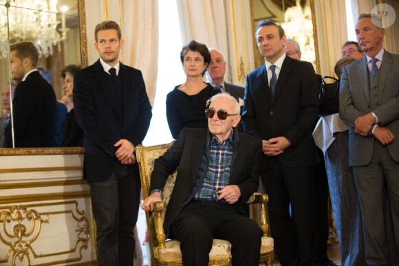 Charles Aznavour est décoré au grade de Commandeur de l'Ordre de la Couronne de Belgique à Bruxelles le 16 novembre 2015. Son fils Nicolas se tient à sa droite derrière lui.