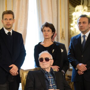 Charles Aznavour est décoré au grade de Commandeur de l'Ordre de la Couronne de Belgique à Bruxelles le 16 novembre 2015. Son fils Nicolas se tient à sa droite derrière lui.