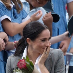 Le prince Harry et Meghan Markle accueillis par des élèves australiens, ont vécu un adorable moment lorsqu'un petit garçon de 5 ans, atteint de trisomie 21, a sauté dans les bras du prince avant de faire un câlin à la duchesse à leur arrivée à Dubbo, le 17 octobre 2018.