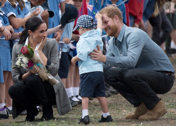 Le prince Harry et Meghan Markle accueillis par des élèves australiens, ont vécu un adorable moment lorsqu'un petit garçon de 5 ans, atteint de trisomie 21, a sauté dans les bras du prince avant de faire un câlin à la duchesse à leur arrivée à Dubbo, le 17 octobre 2018.
