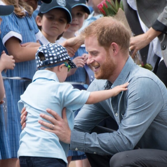 Le prince Harry et Meghan Markle accueillis par des élèves australiens, ont vécu un adorable moment lorsqu'un petit garçon de 5 ans, atteint de trisomie 21, a sauté dans les bras du prince avant de faire un câlin à la duchesse à leur arrivée à Dubbo, le 17 octobre 2018.