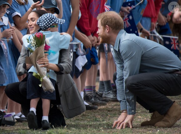 Le prince Harry et Meghan Markle accueillis par des élèves australiens, ont vécu un adorable moment lorsqu'un petit garçon de 5 ans, atteint de trisomie 21, a sauté dans les bras du prince avant de faire un câlin à la duchesse à leur arrivée à Dubbo, le 17 octobre 2018.