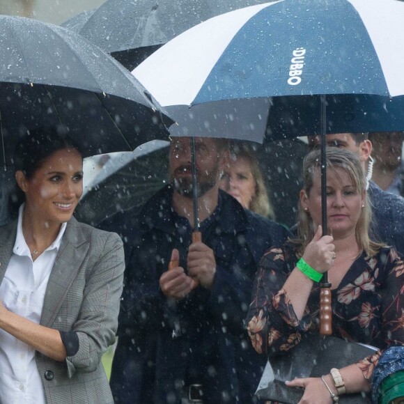 Le prince Harry a prononcé un discours aux côtés de sa femme Meghan Markle au Victoria Park de la ville de Dubbo en Australie, le 17 octobre 2018. Un orage a éclaté et c'est sous un parapluie (tenu par la duchesse) que le prince Harry a fait son discours.