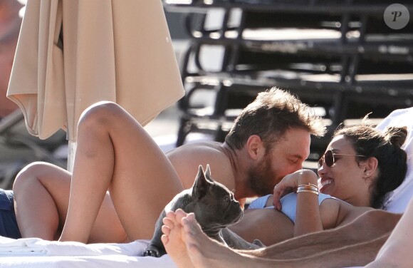 David Guetta et sa compagne Jessica Ledon profitent d'une belle journée ensoleillée en compagnie de leur petit Bulldog sur une plage à Miami le 19 novembre 2018