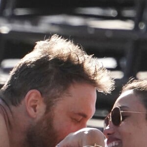 David Guetta et sa compagne Jessica Ledon profitent d'une belle journée ensoleillée en compagnie de leur petit Bulldog sur une plage à Miami le 19 novembre 2018