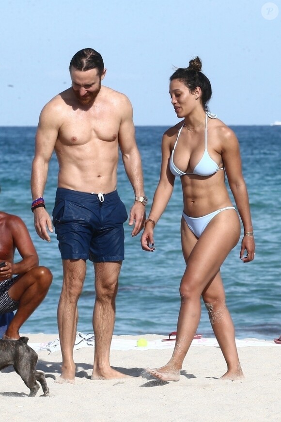 David Guetta et sa compagne Jessica Ledon profitent d'une belle journée ensoleillée en compagnie de leur petit Bulldog sur une plage à Miami le 19 novembre 2018
