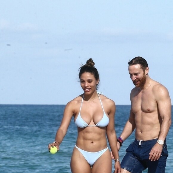 David Guetta et sa compagne Jessica Ledon profitent d'une belle journée ensoleillée en compagnie de leur petit Bulldog sur une plage à Miami le 19 novembre 2018