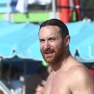 David Guetta et sa compagne Jessica Ledon profitent d'une belle journée ensoleillée en compagnie de leur petit Bulldog sur une plage à Miami le 19 novembre 2018