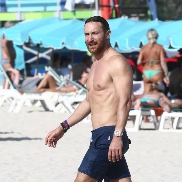 David Guetta et sa compagne Jessica Ledon profitent d'une belle journée ensoleillée en compagnie de leur petit Bulldog sur une plage à Miami le 19 novembre 2018