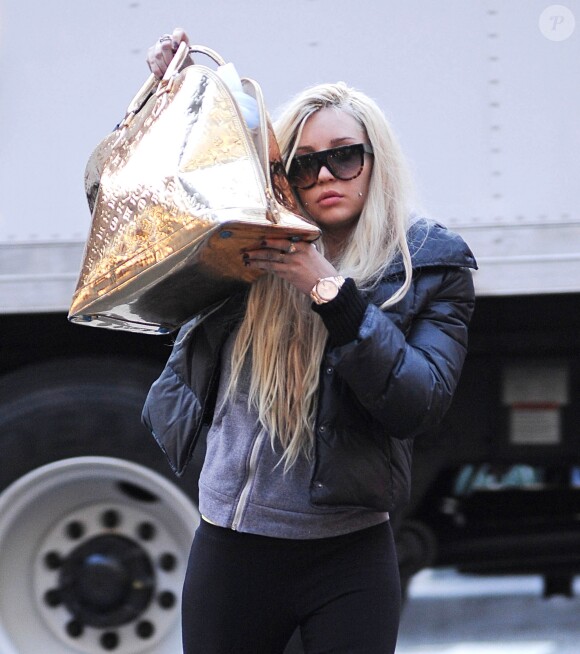 L'actrice et chanteuse Amanda Bynes se cache derriere son sac Louis Vuitton alors qu'elle marche dans les rues de New York. Le 8 avril 2013