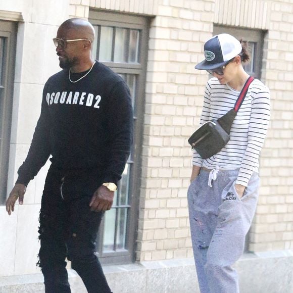 Faisant fi des nombreuses rumeurs concernant leur rupture, Katie Holmes et Jamie Foxx se promènent main dans la main et se sourient amoureusement dans les rues ensoleillées de New York. Katie porte une marinière blanche et bleue, un pantalon de jogging oversize gris, de larges lunettes de soleil, une casquette, un sac banane et une paire de baskets All Stars Adidas. Jamie porte un sweatshirt noir Dsquared2, un pantalon noir, une paire de baskets blanches, une longue veste bi-matière bleue marine et noire, une large montre dorée et une fine chaine en or ainsi que des lunettes de soleil. New York, le 16 avril 2019.1