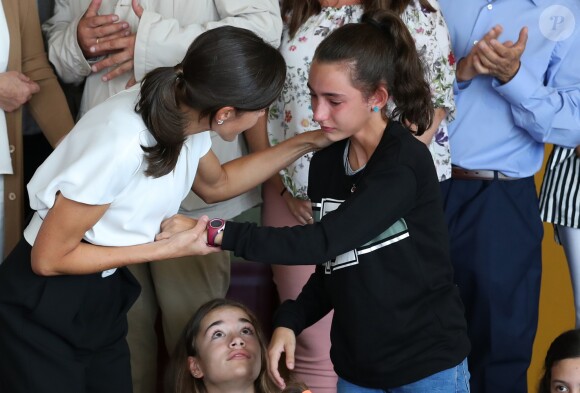 La reine Letizia d'Espagne réconfortant une fillette un peu trop émue de la voir lors du lancement officiel de l'année scolaire dans une école à Torrejoncillo, près de Caceres, le 17 septembre 2019.
